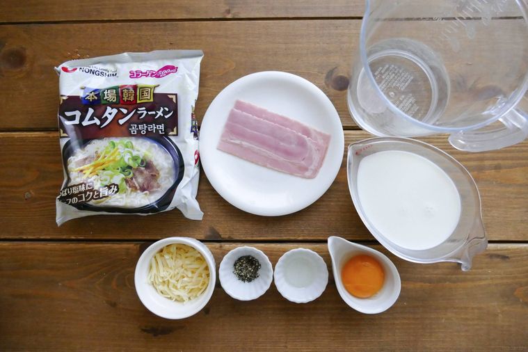カルボナーラ風コムタンラーメンの材料が並ぶ木製テーブル