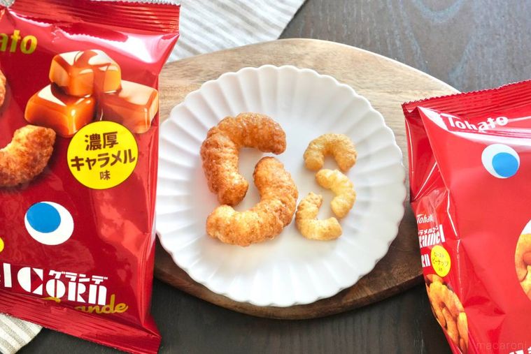 木のカッティングボードと白い皿にのったキャラメルコーンとグランデサイズと赤いパッケージの袋