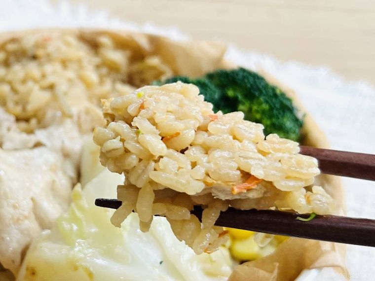 蒸し野菜と豚しゃぶのサラダごはんの炊き込みごはんを箸で持ち上げている様子
