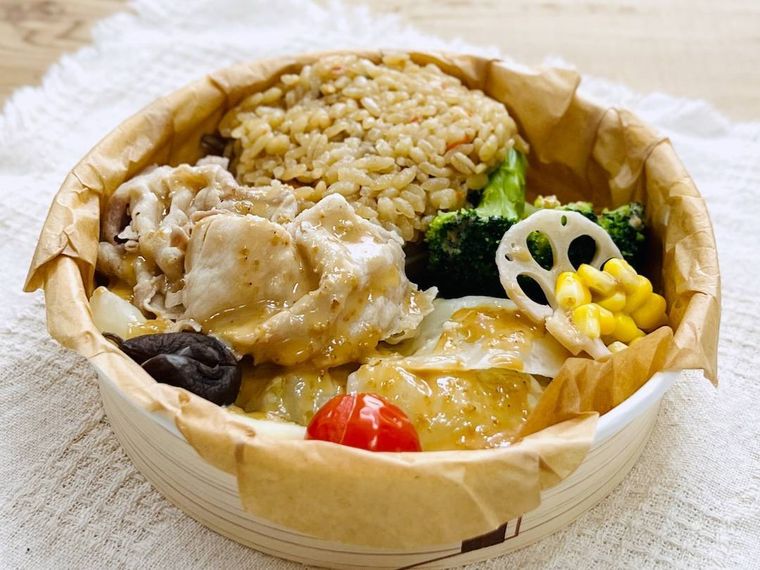セブンイレブンの蒸し野菜と豚しゃぶのサラダごはんにごまだれをかけた様子