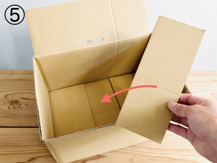 段ボールの切れ端を手で持っている様子