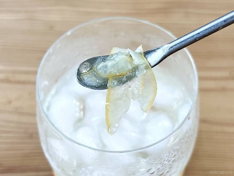 レモンスカッシュの底に沈んだレモンピールを、スプーンですくった様子