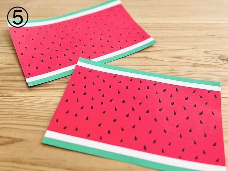 赤い画用紙にスイカの種を描いた様子