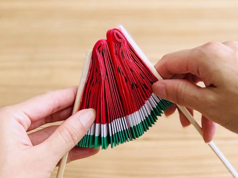 画用紙で作ったスイカ扇子を畳んでいる様子