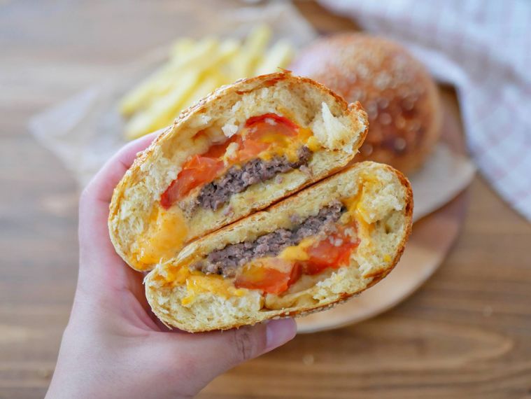 半分に切ったクローズドバーガーを手で持つ様子