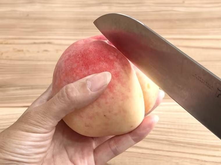 桃に包丁を当てている様子