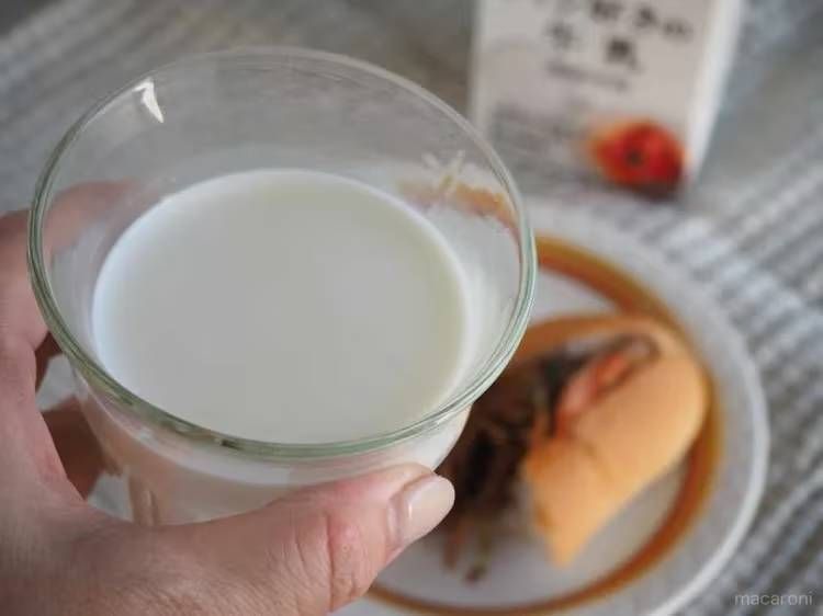 牛乳が入ったグラスを手で持っている様子