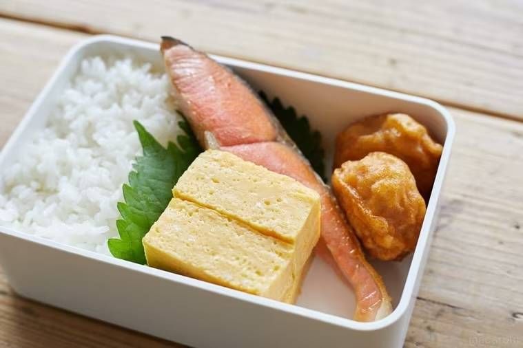 お弁当箱に鮭や卵焼きなどを詰めた様子