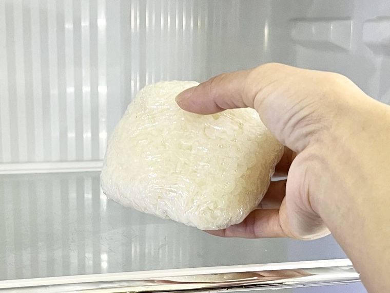 ラップで包んだご飯を冷蔵庫に入れようとしている様子