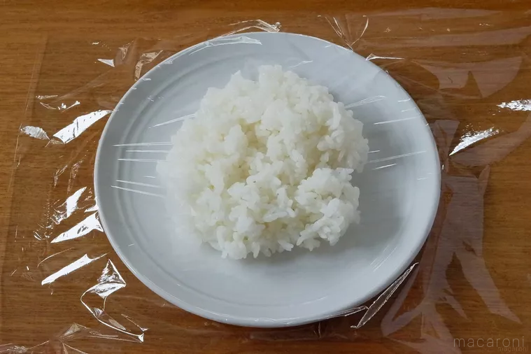 白いプレートに盛り付けられたごはん、上にラップをかけている。