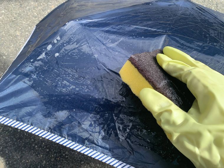 日傘をスポンジで洗う様子