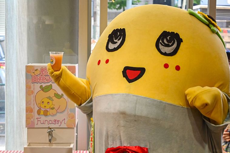 ふなっしーが桃ジュースを持っているところ
