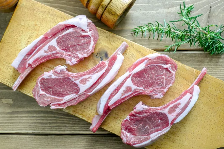 まな板の上にラムチョップの生肉が4本並べられている様子