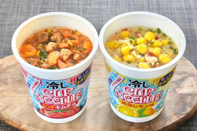木のカッティングボードにのったピリ辛キムチ味と鶏塩レモン味のカップヌードル