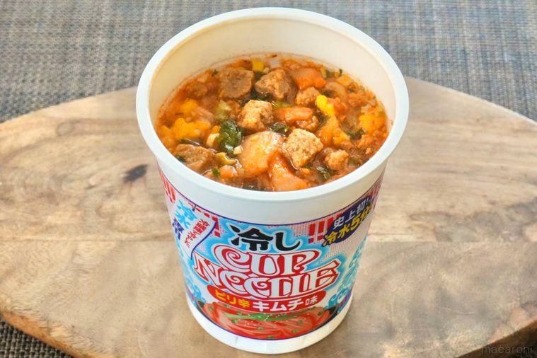 木のカッティングボードにのった冷しカップヌードルピリ辛キムチ味