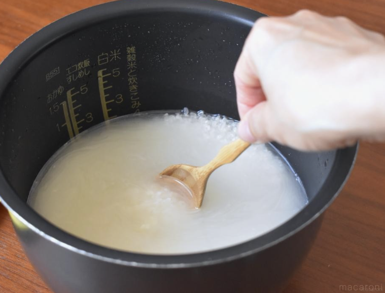スプーンを添えた炊飯器の中の米