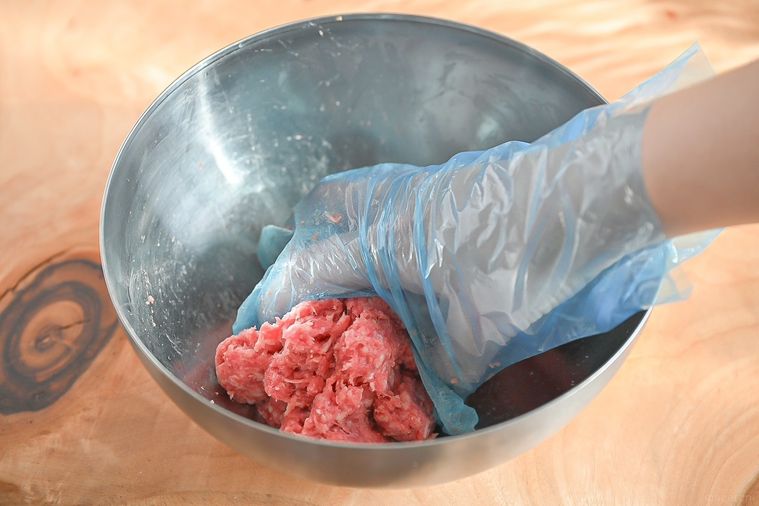 ボウルに入ったひき肉を捏ねている様子
