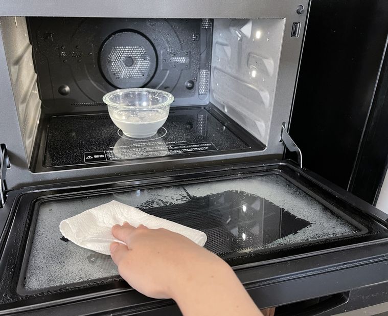 電子レンジの汚れを拭き取っている様子
