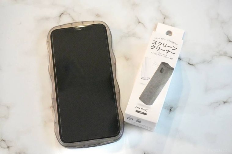 大理石風の背景とスマートフォンと百均のスクリーンクリーナー