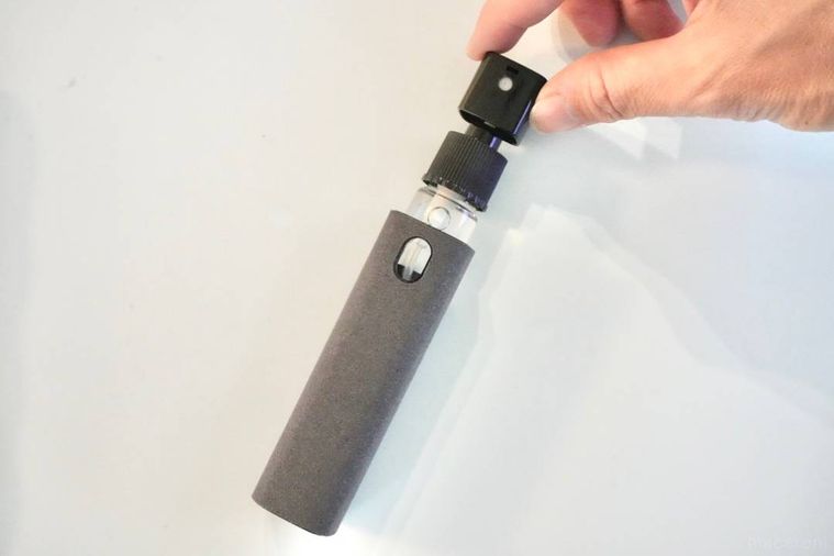 グレーのクリーナーからスプレーボトルを引き出す様子