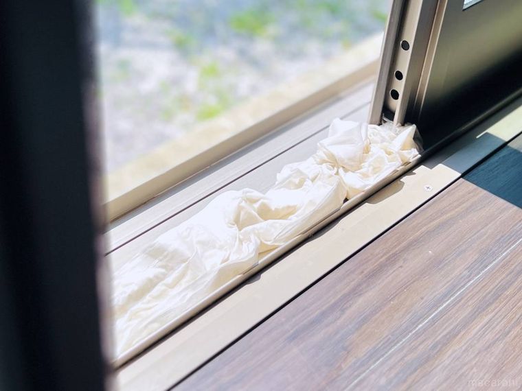 サッシにトイレットペーパーを敷き、窓を閉めている様子