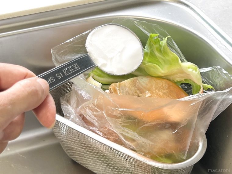 生ゴミが入ったポリ袋に重曹を振りかけている様子