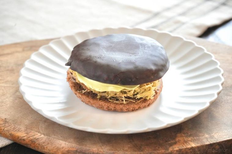 木のカッティングボードと白い皿にのったドバイチョコをイメージしたチョコブッセサンド