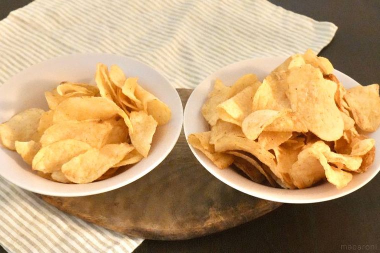 木のカッティングボードとピンク色の皿に盛られたわさビーフポテトチップス