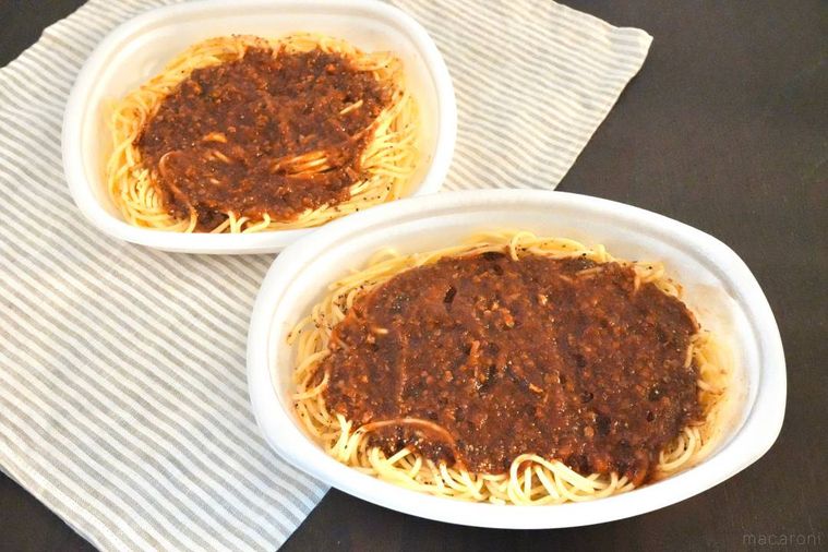 白い発泡スチロール容器に盛られた大盛りのミートソースパスタ