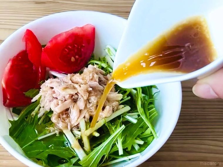 ツナ缶の油で作ったドレッシングをサラダにかけている様子