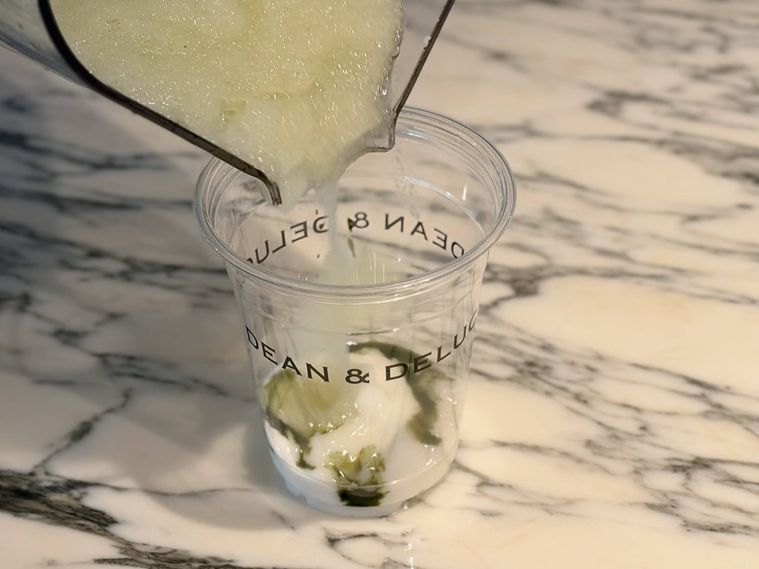 ブランマンジェと抹茶の入ったカップにフラッペを入れる様子