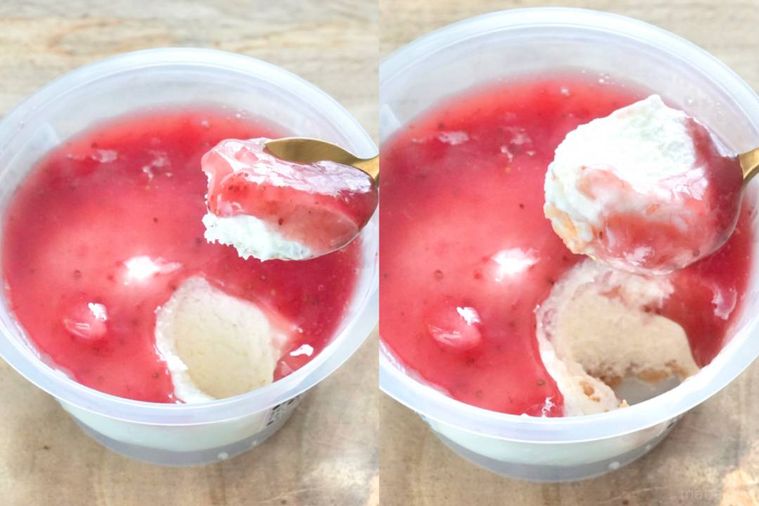 木のカッティングボードにのったベリーソースのせのチーズドルチェを金のスプーンで食べる様子