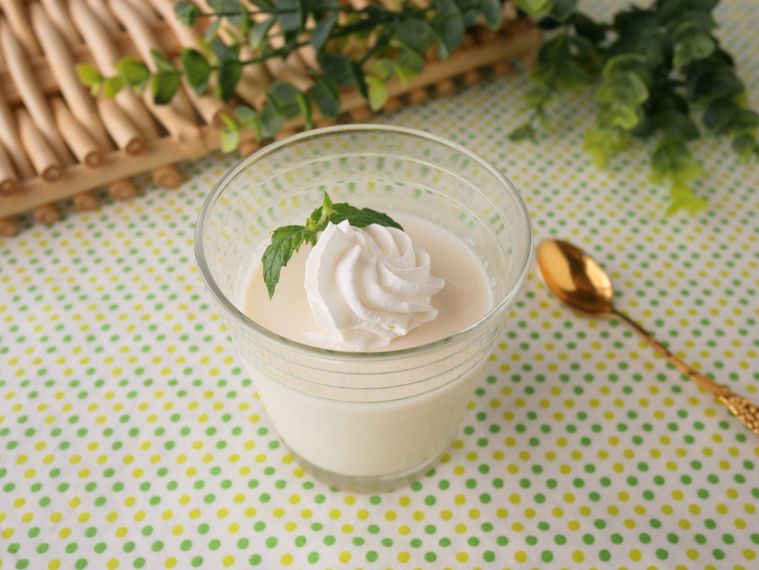 スプーンを添えた豆腐プリンのホイップクリームのせ