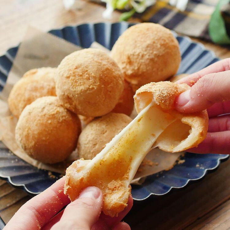 チーズボールを手でふたつにちぎっている様子