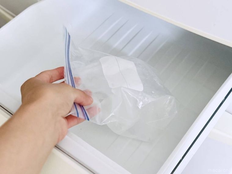 氷が入ったジッパー付きの保存袋を冷凍庫に格納している様子