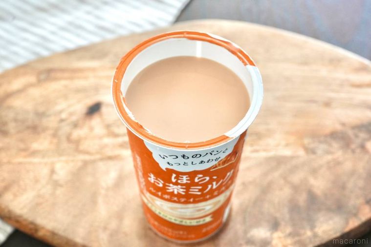 オレンジ色のパッケージのルイボスティーミルクのカップの中身とストライプの布