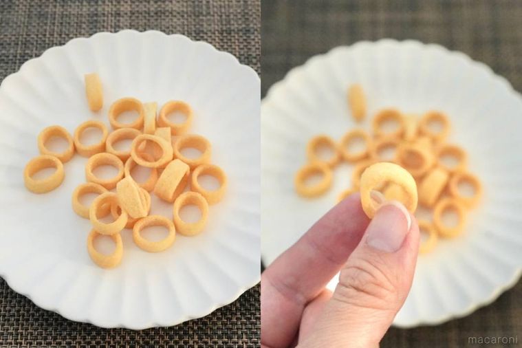 白い皿に盛られたじゃがバター味のポテトスナック菓子を手に持つ様子