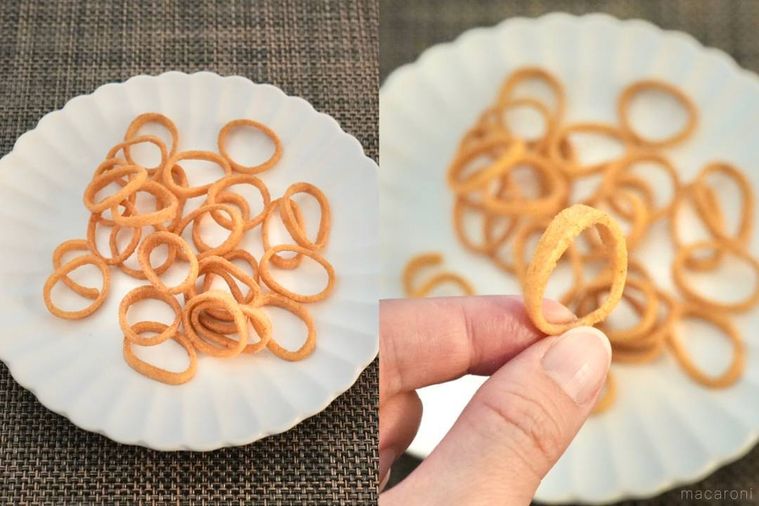 白い皿に盛られた焼きそば味のポテトスナック菓子を手に持つ様子