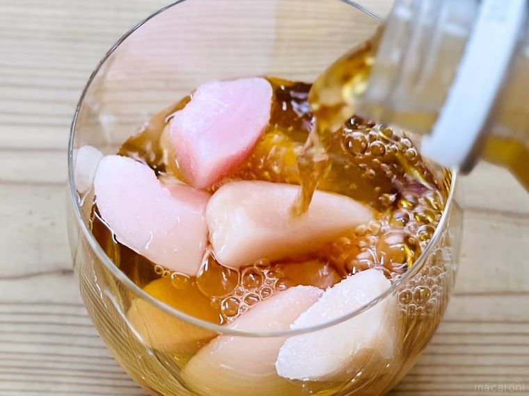 冷凍桃が入ったグラスにアイスティーをそそいでいる様子