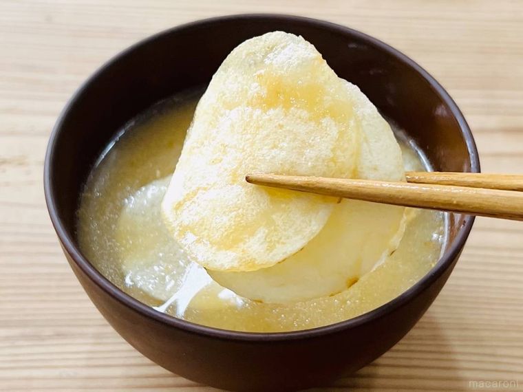 味噌汁に入れたポテトチップスを箸で持ち上げている様子