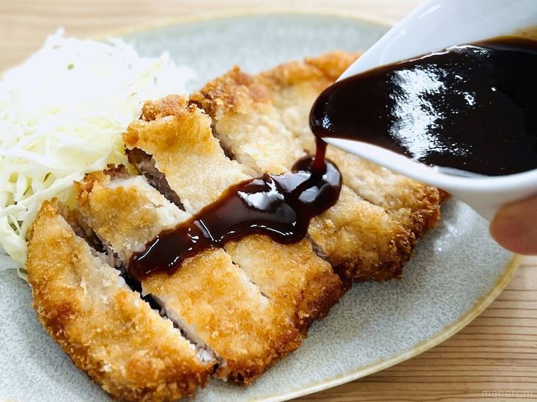 とんかつにとんかつソースをかけている様子