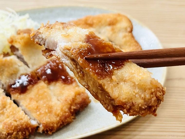 とんかつを箸で持ち上げている様子