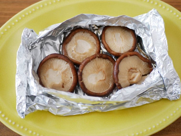 ホイル焼きのしいたけが黄色い皿に盛られている