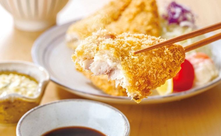 アジフライを持ち上げている