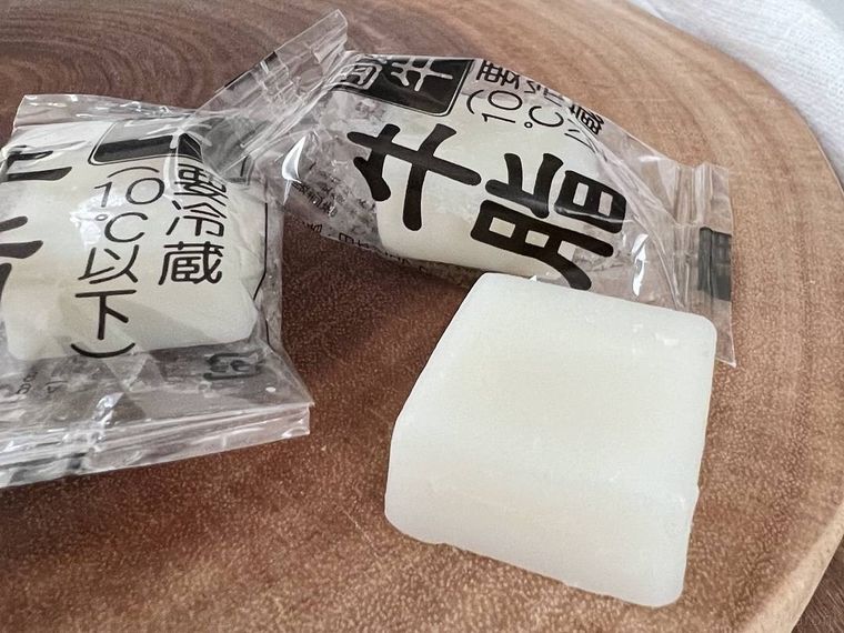 木のまな板の上に、透明の袋に入った牛脂2個と、むきだしの牛脂1個が置かれている