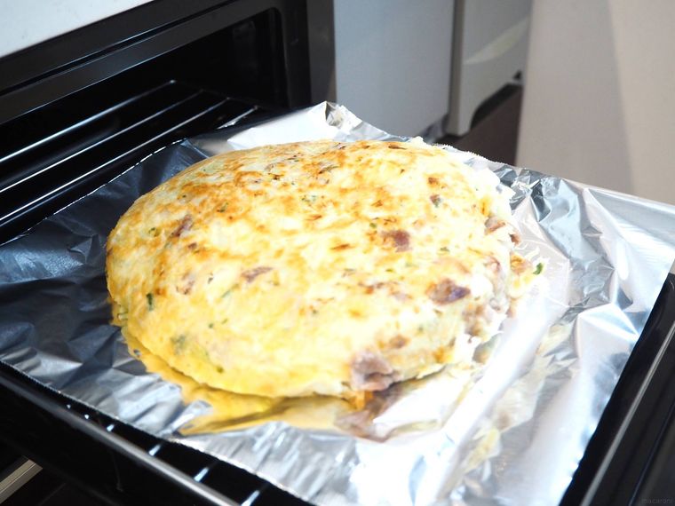アルミホイルにのせたお好み焼きを魚焼きグリルにのせた様子
