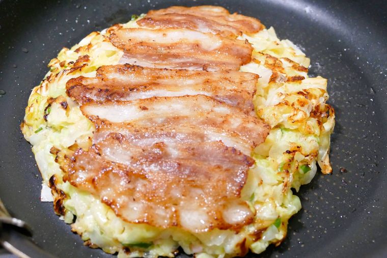 フライパンでお好み焼きを焼いている様子