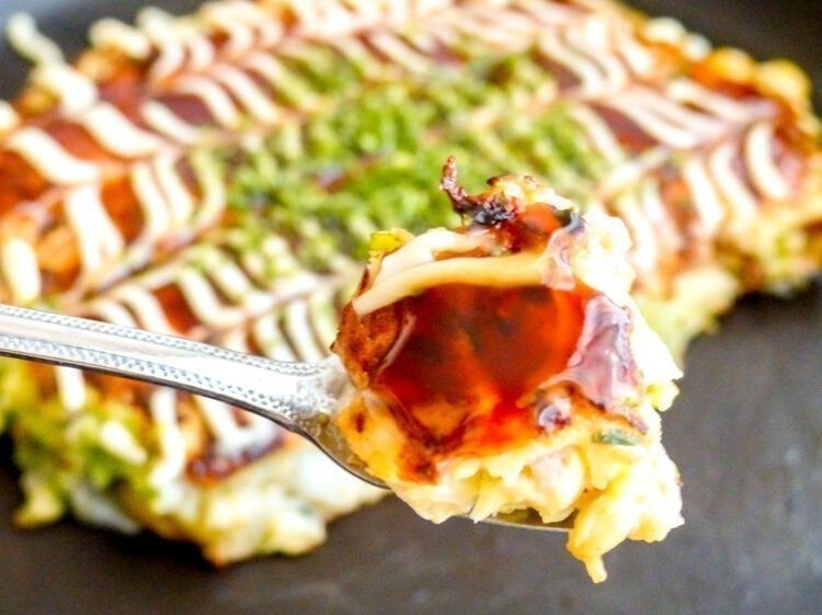 小さく切ったお好み焼きを小さなテココテで持ち上げる様子