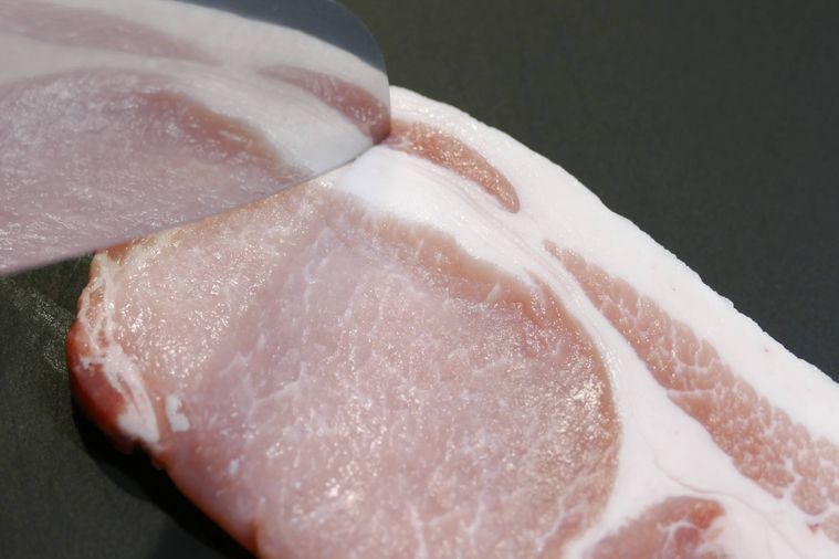 豚肉の筋に包丁の刃先を入れる様子