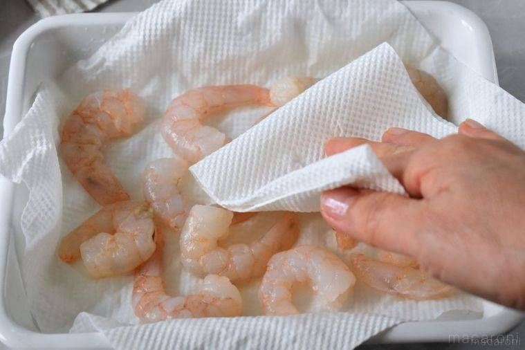 解凍したむきえびをキッチンペーパーで拭く様子